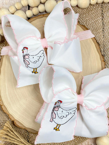 White bows with chicken illustrations on a wooden surface