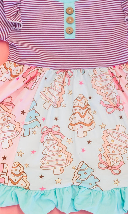 close up of tiered pattern of christmas tree cakes on skirt of the dress