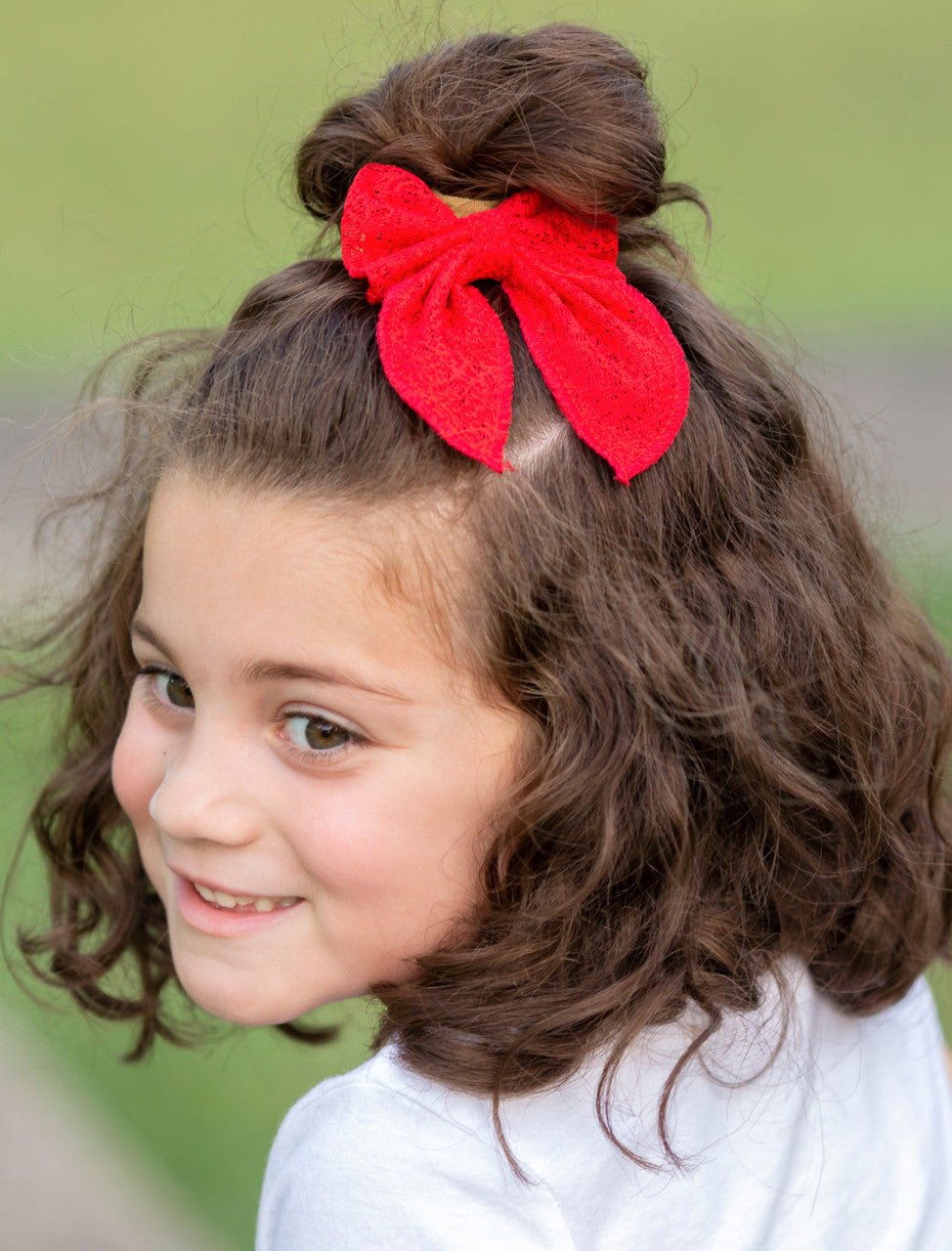 Girl wearing a red classic eyelet lace hair bow