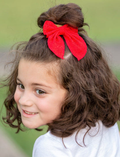 Girl wearing a red classic eyelet lace hair bow