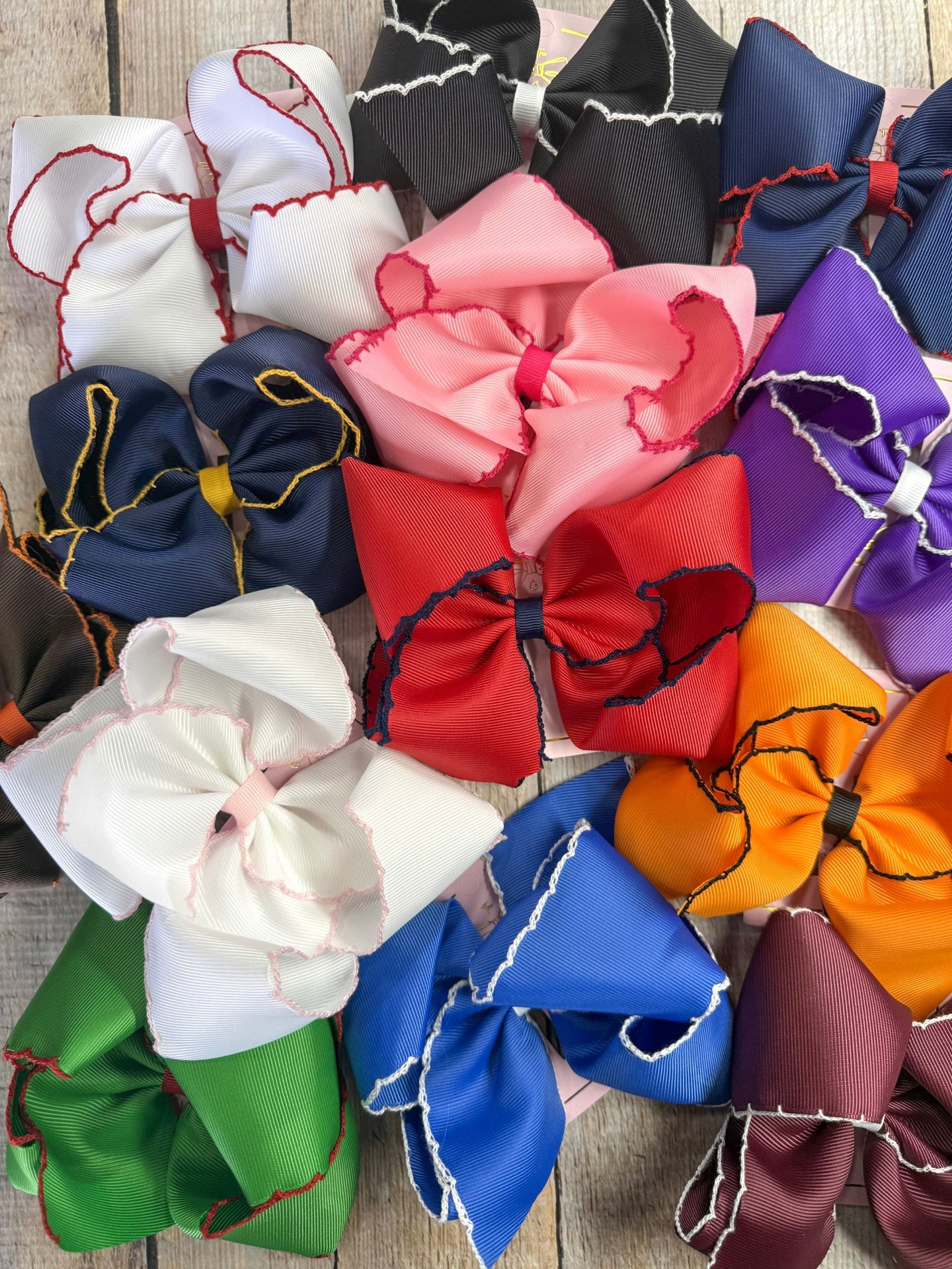 Colorful moontitch bows arranged in a circular pattern on a wooden surface.