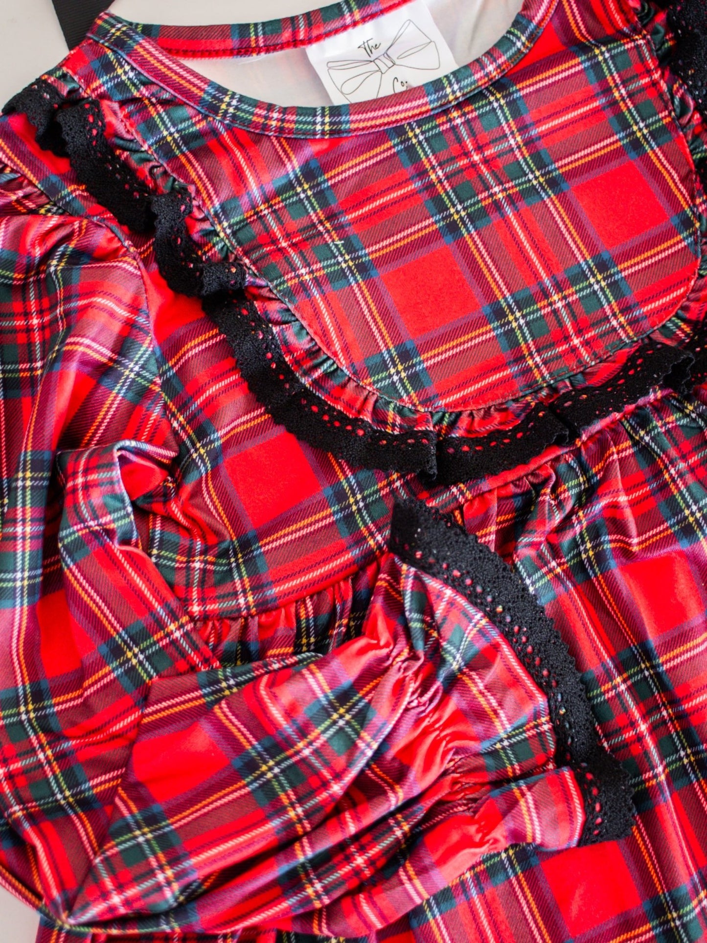 Red plaid dress with black trim on a white background