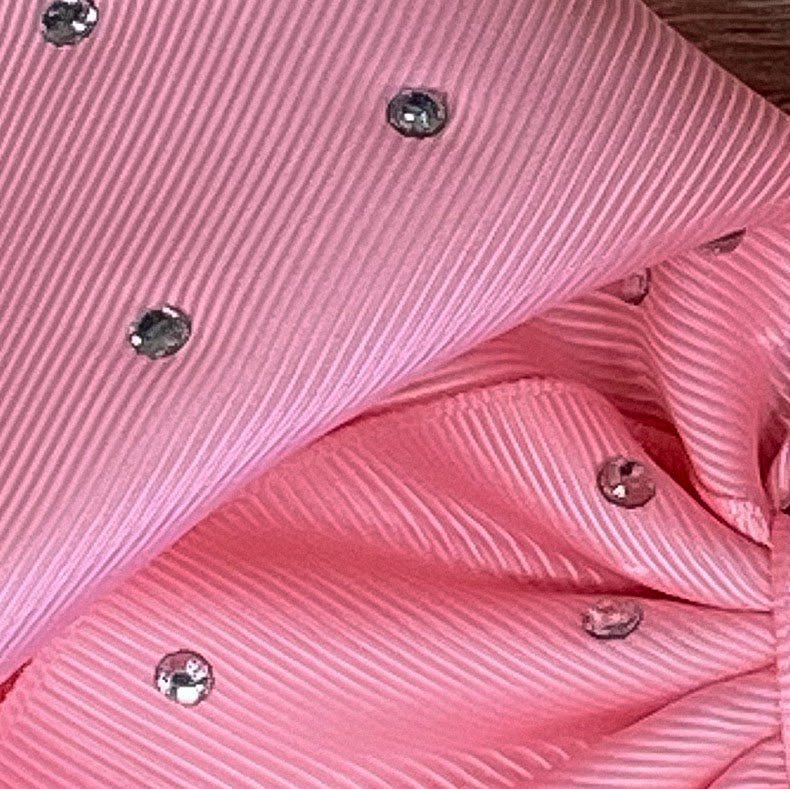 A hair bow close up of ribbon with clear rhinestones  on pink 