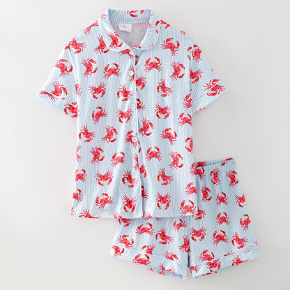 Children's pajama set with red crab pattern on a light blue background