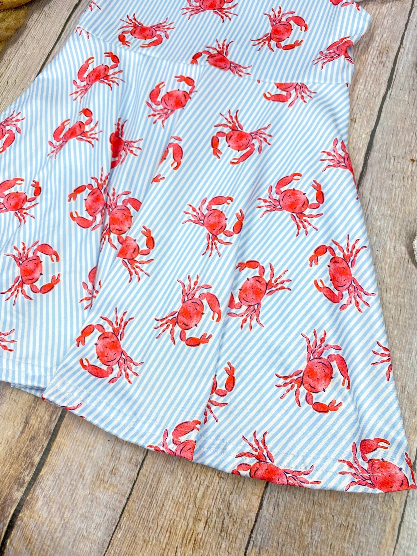 Dress with red crab pattern on a wooden background