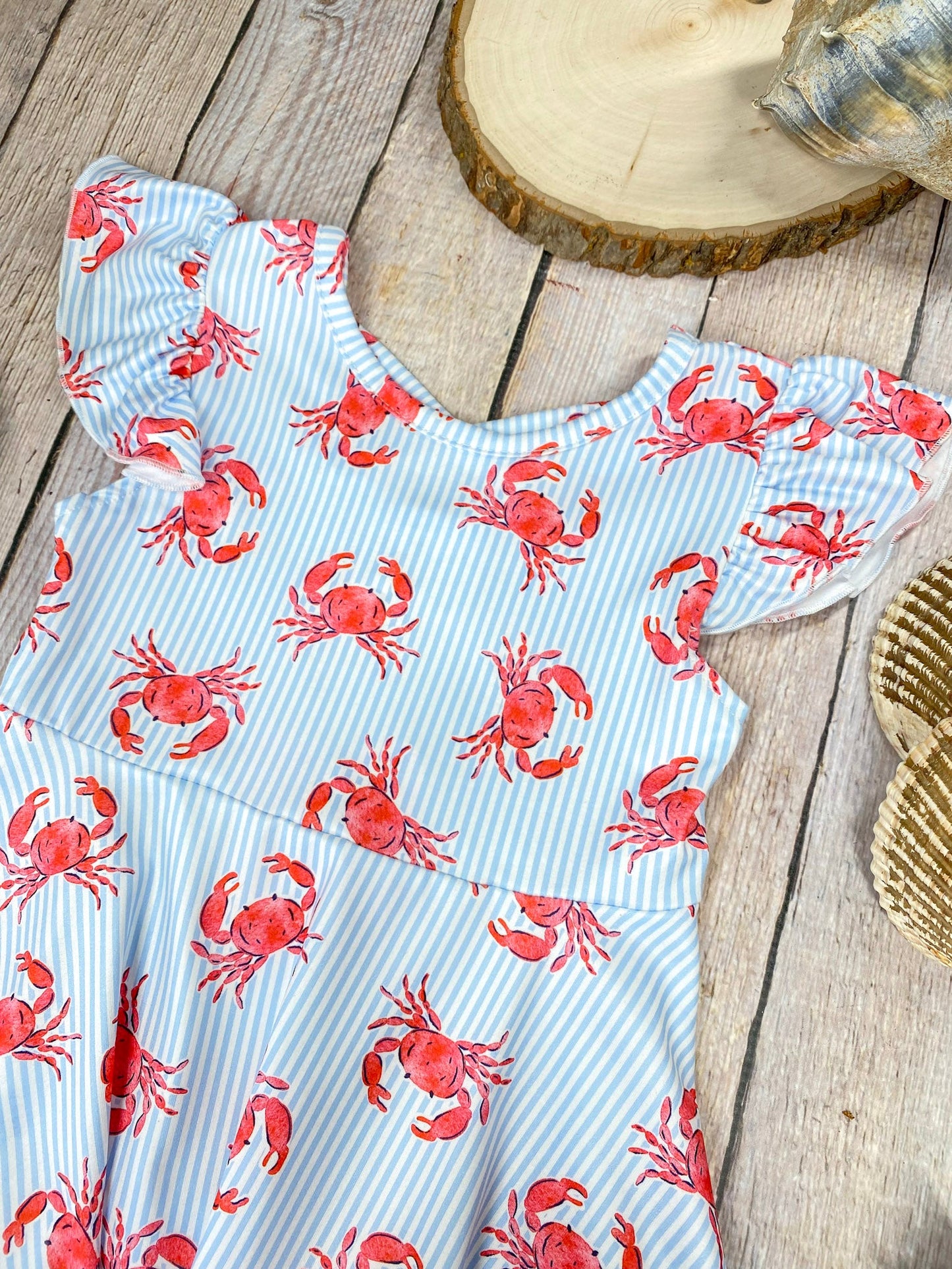 Dress with red crab pattern on a wooden background