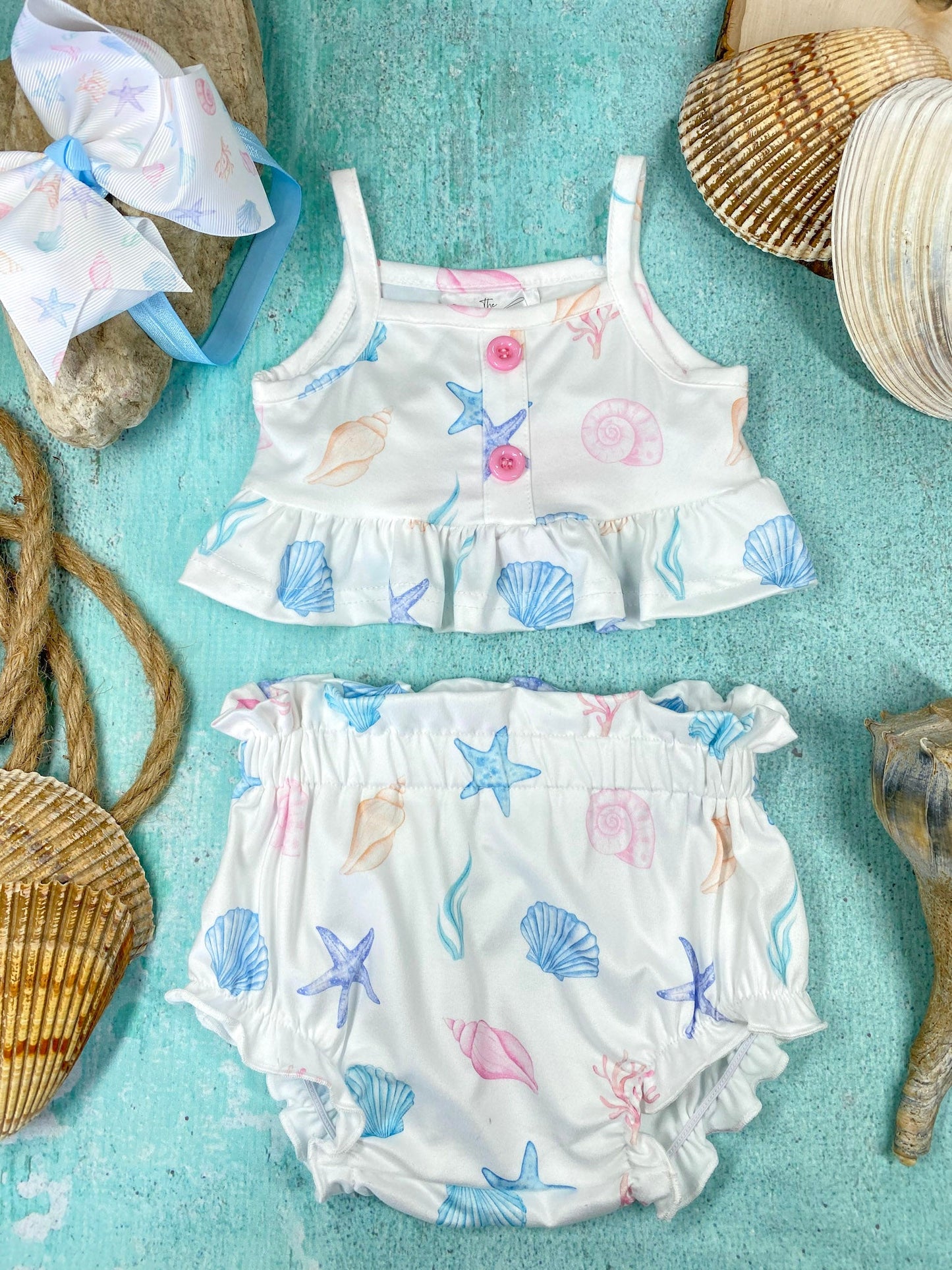 Children's two-piece romper with shell and starfish pattern on a blue background