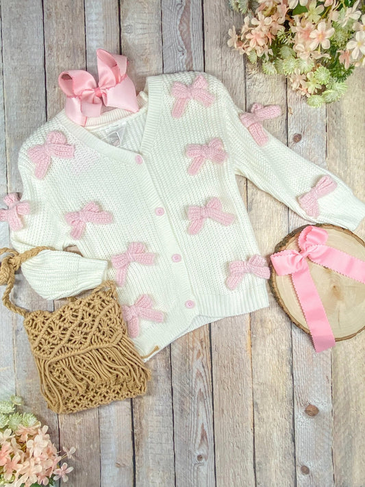 white cardigan sweater with light pink knitted bows on front