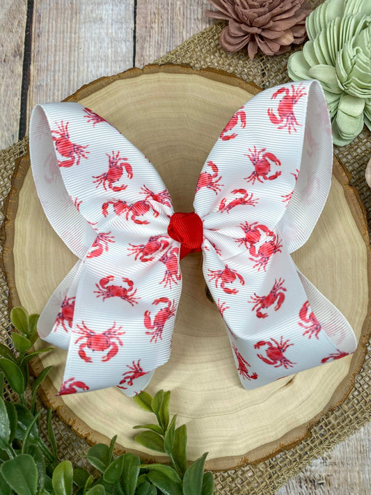 White hair bow with red patterns on a decorative plate with flowers in the background