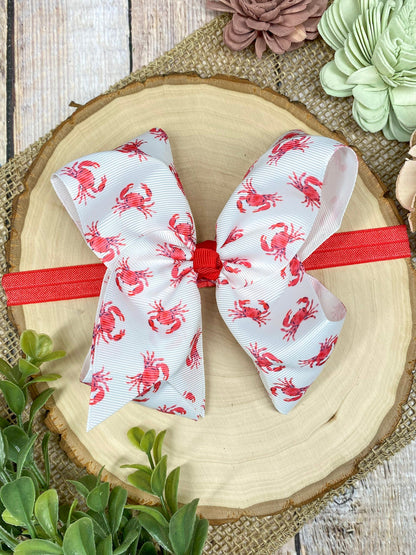 White headband with red patterns on a decorative plate with flowers in the background
