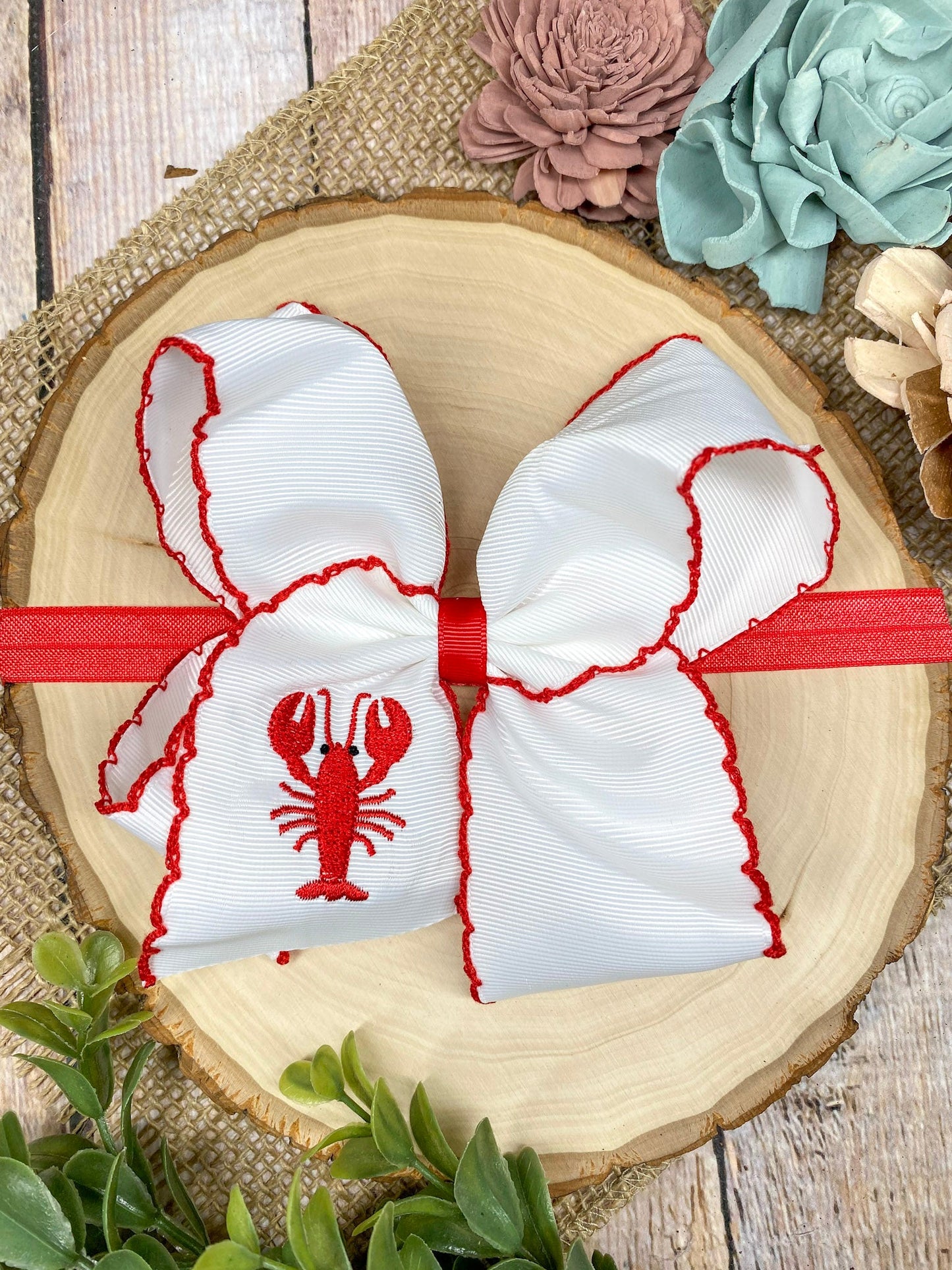 The Crawfish & Lobster Embroidered Moonstitch Headband on a wooden background