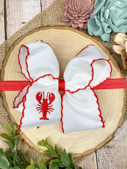 The Crawfish & Lobster Embroidered Moonstitch Headband on a wooden background