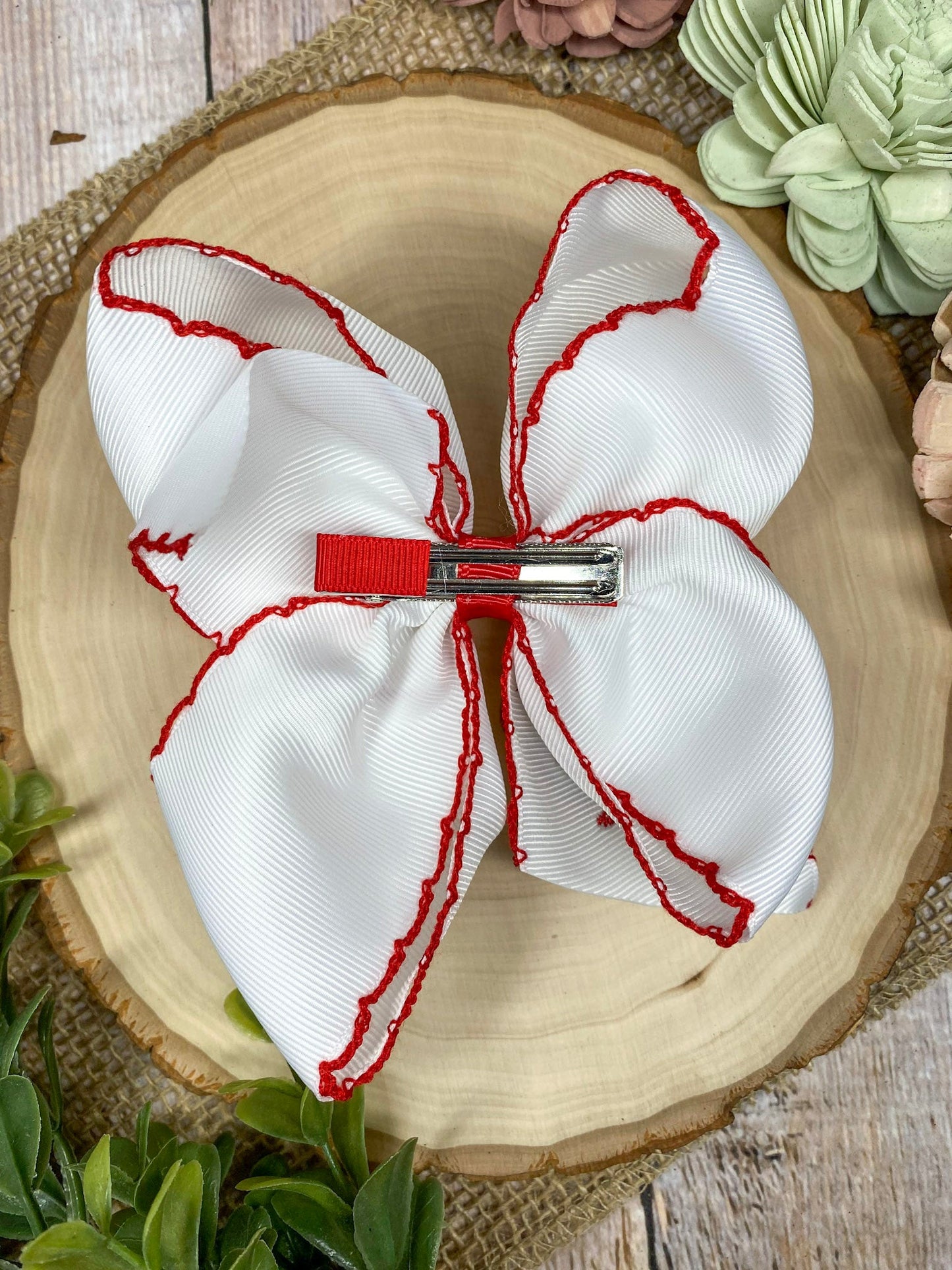 The Crawfish & Lobster Embroidered Moonstitch Hair Bow on a wooden background