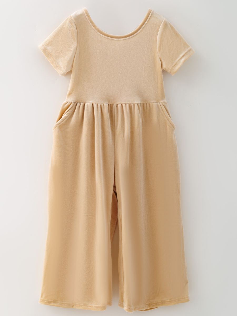 Ivory girls’ velvet wide-leg jumpsuit with short sleeves and side pockets.
