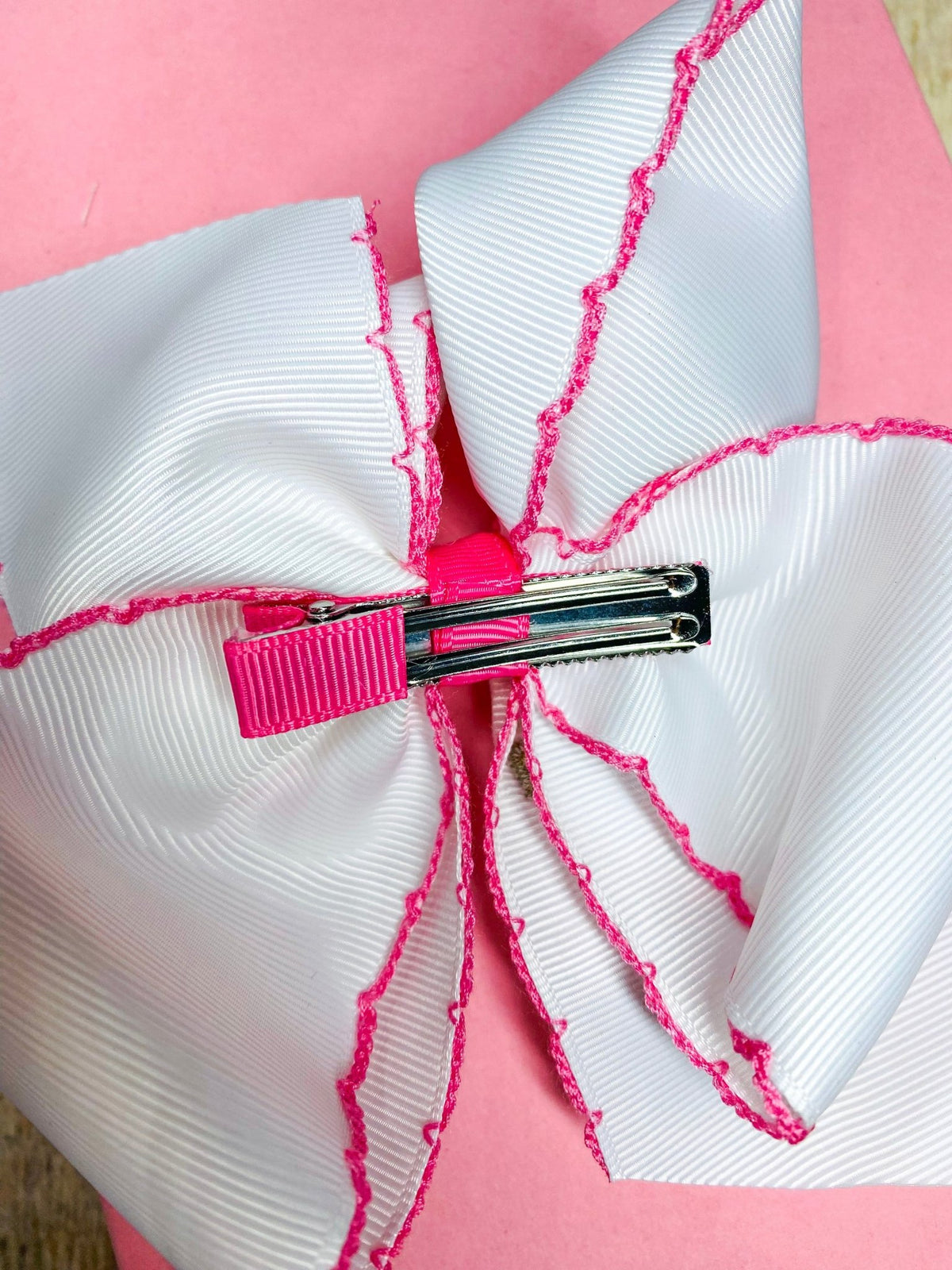 Cross moonstitch embroidered hair bow showing alligator clip