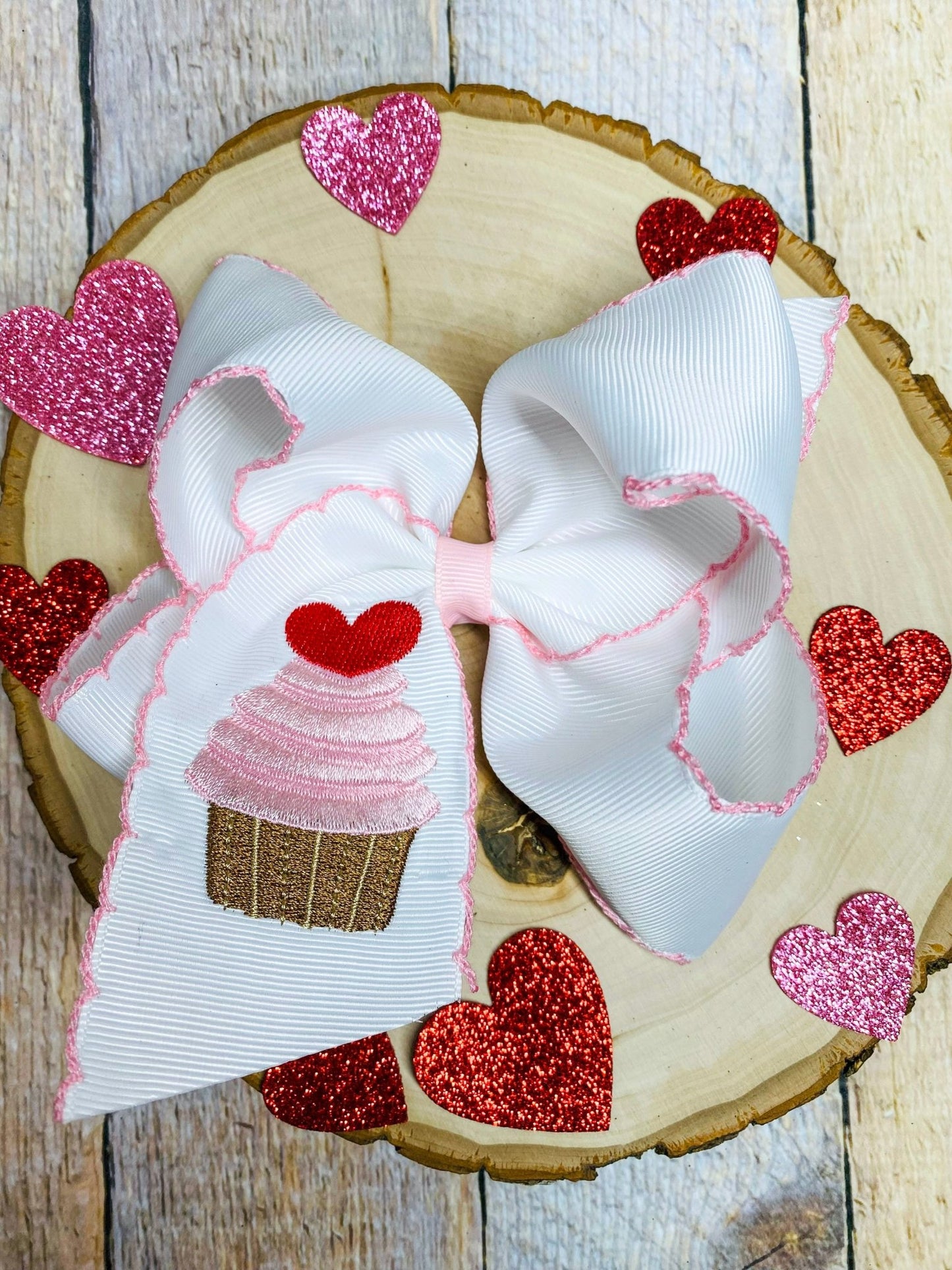 Large decorative bow with heart designs on a wooden surface