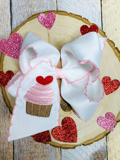 Large decorative bow with heart designs on a wooden surface