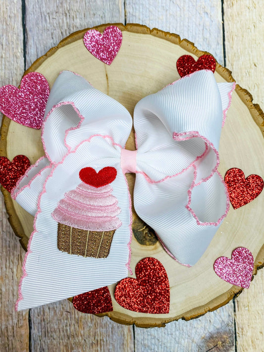 Large decorative bow with heart designs on a wooden surface