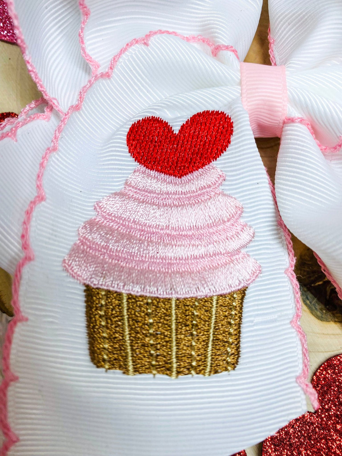 Close-up of cupcake and heart embroidery on moonstitch hair bow