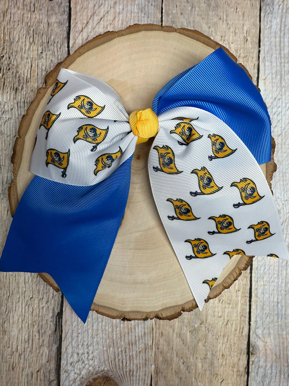 Blue and white custom printed cheer bow on a wooden surface