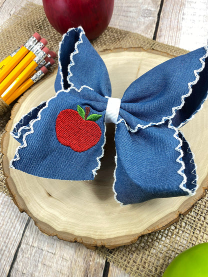 Denim Apple Embroidered Moonstitch Hair Bow on a wooden background