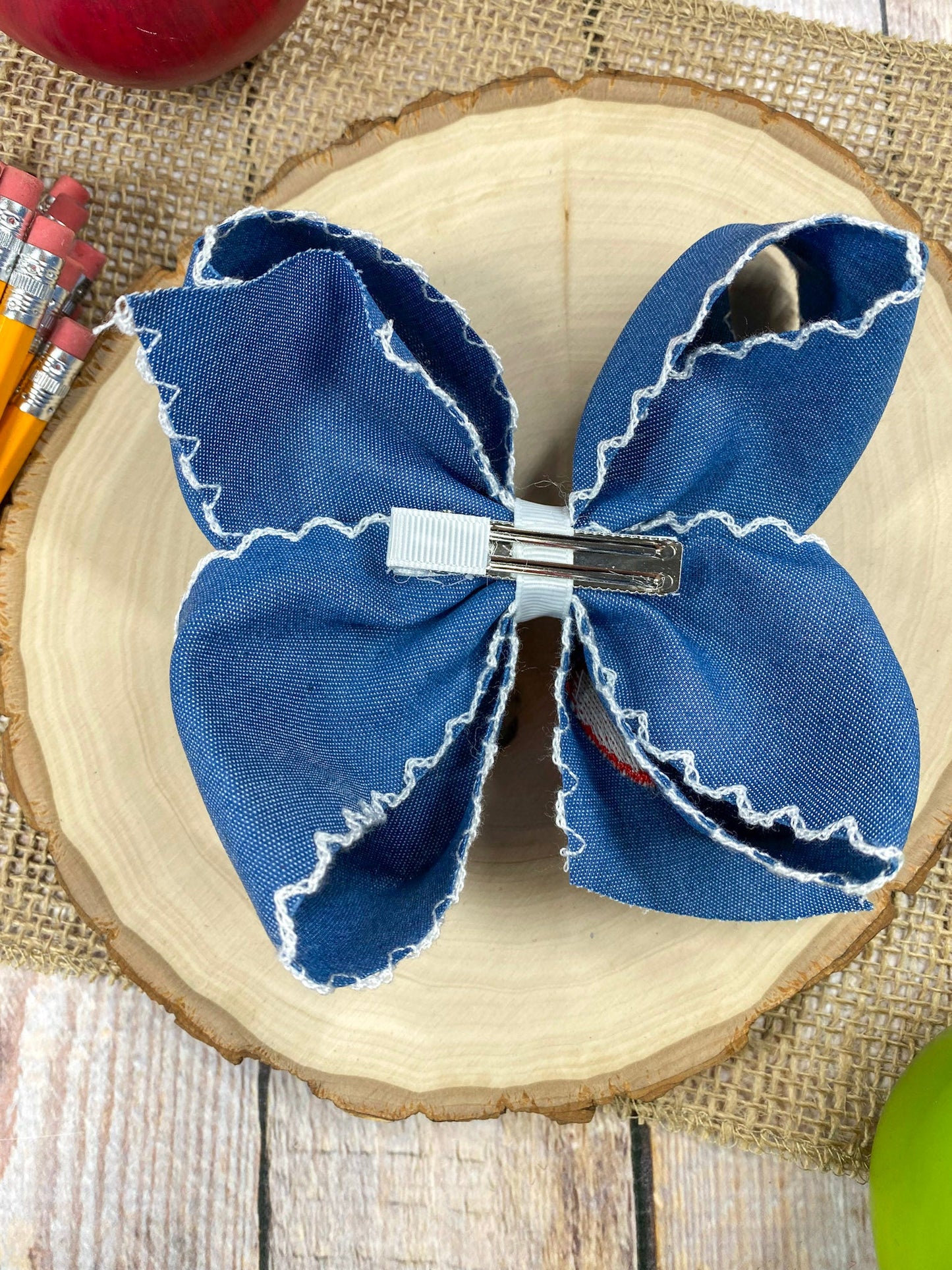 Denim Apple Embroidered Moonstitch Hair Bow on a wooden background