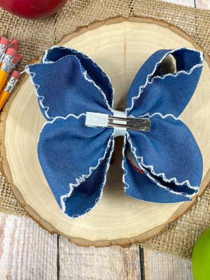 Denim Apple Embroidered Moonstitch Hair Bow on a wooden background