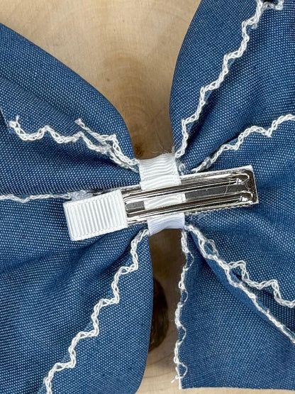 back of Denim blue moonstitch hair bow with white stitched trim