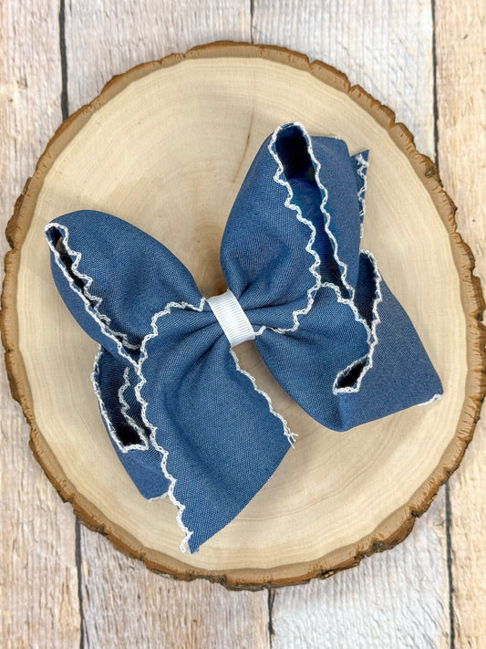 Denim blue hair bow with white moonstitch trim on alligator clip
