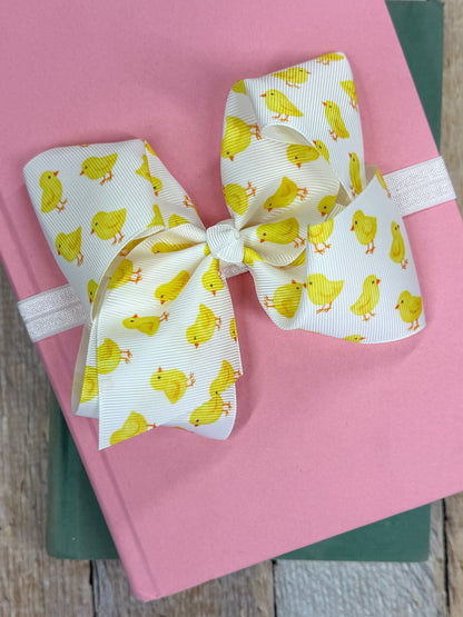 aster chicks headband with white grosgrain bow featuring yellow chick print