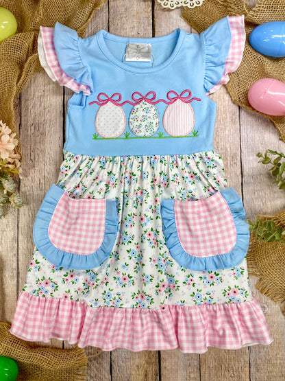 Children's dress with floral pattern and Easter design on a wooden surface