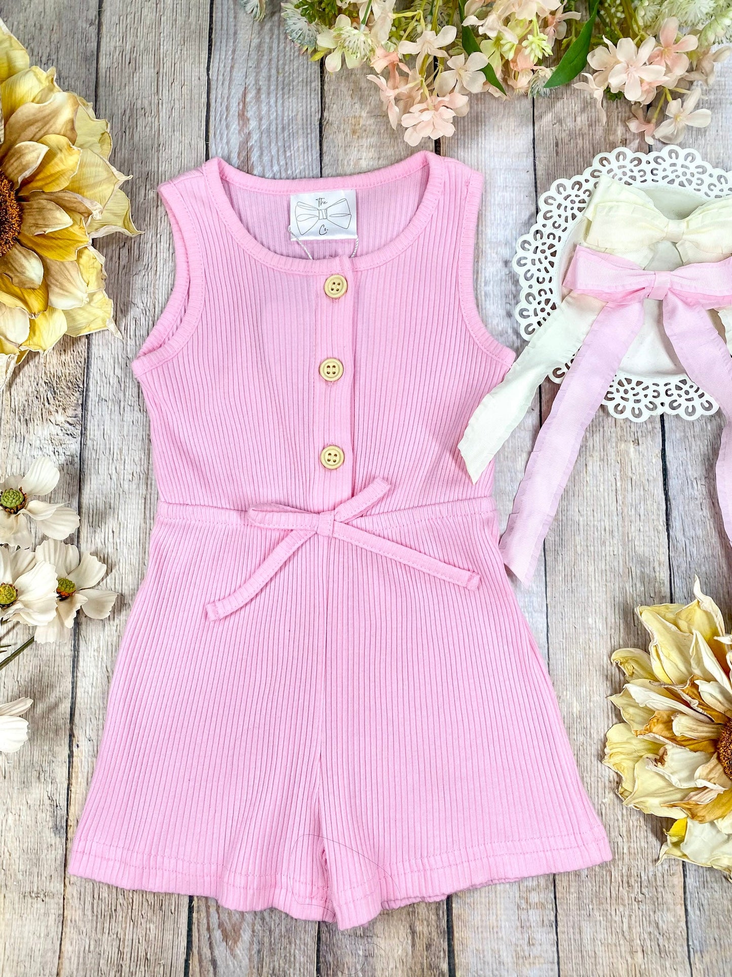 colorful romper in pink on a wooden background
