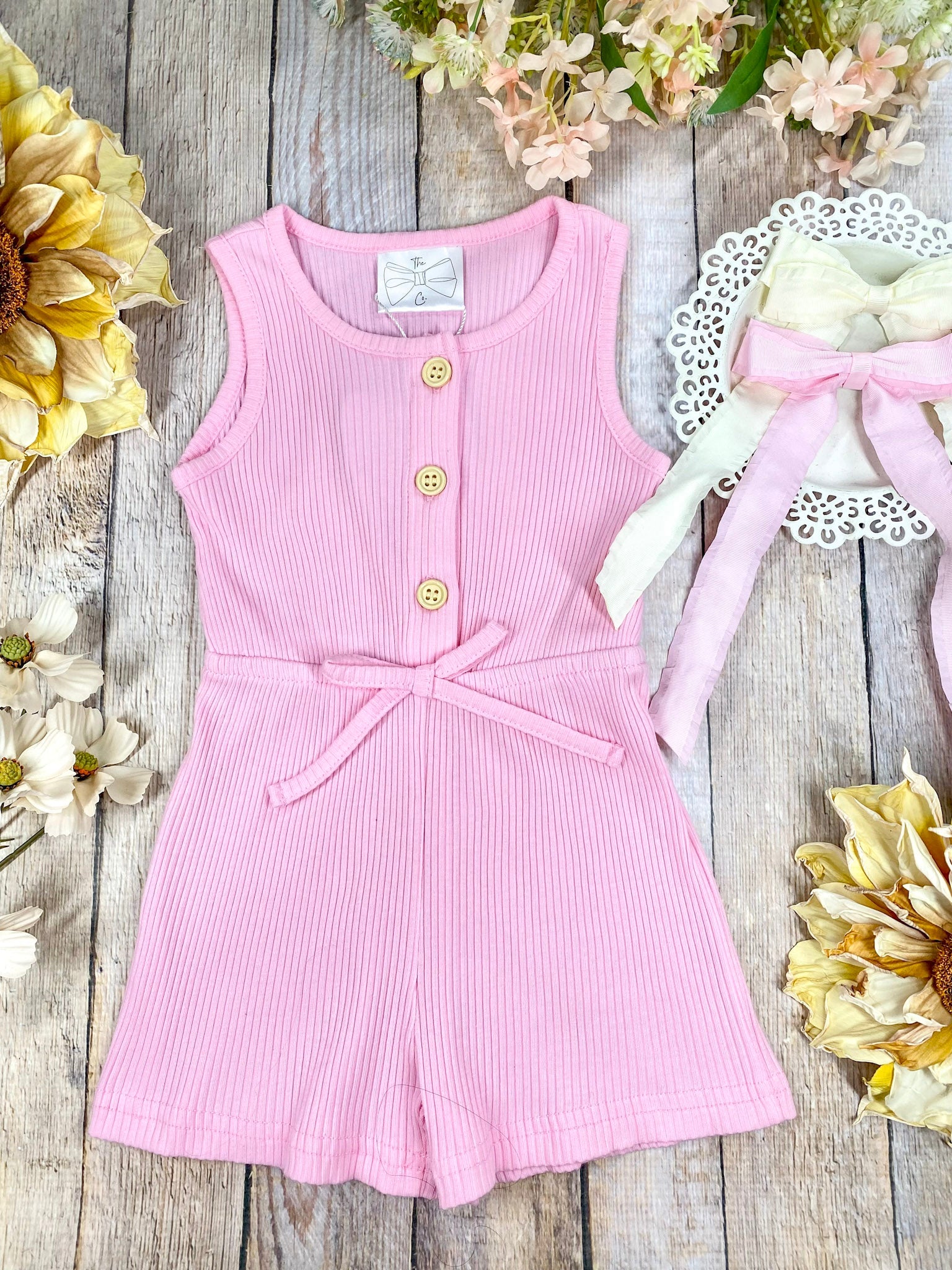 colorful romper in pink on a wooden background