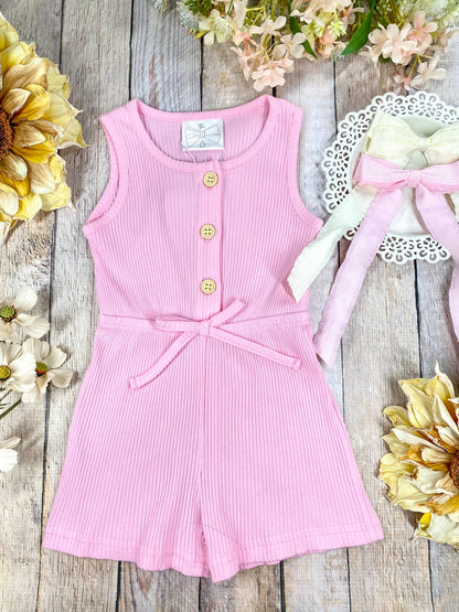 colorful romper in pink on a wooden background