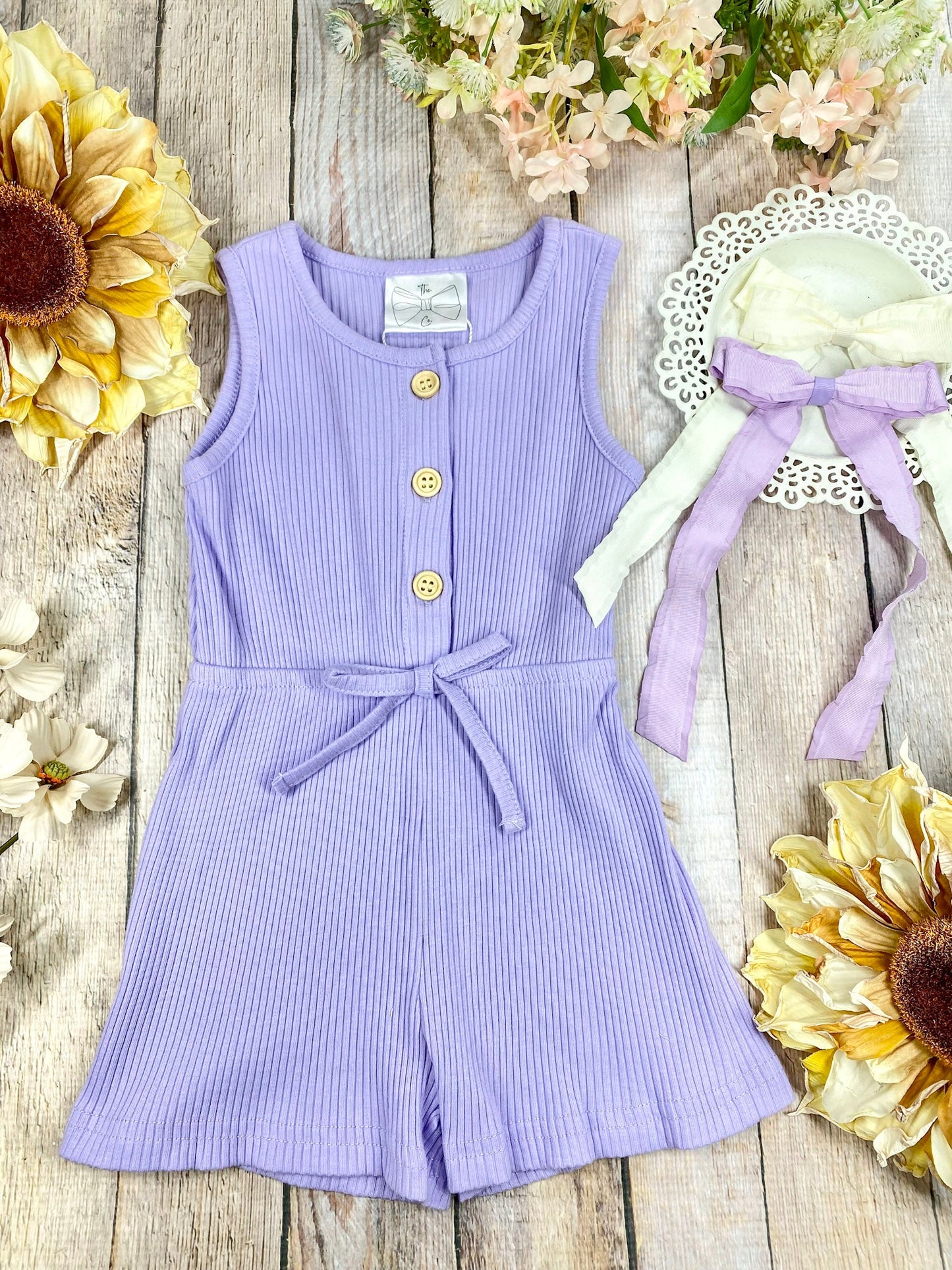 colorful romper in purple on a wooden background