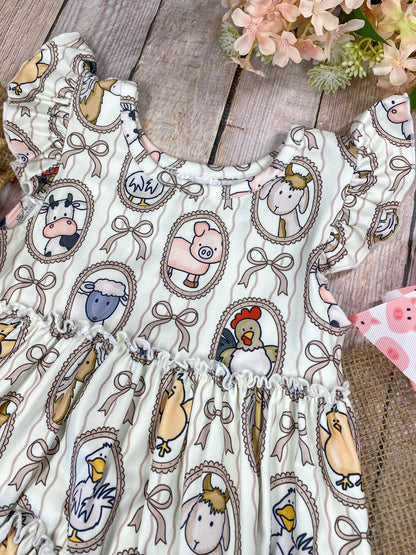 Children's outfit with patterned top and peach-colored shorts on a wooden background