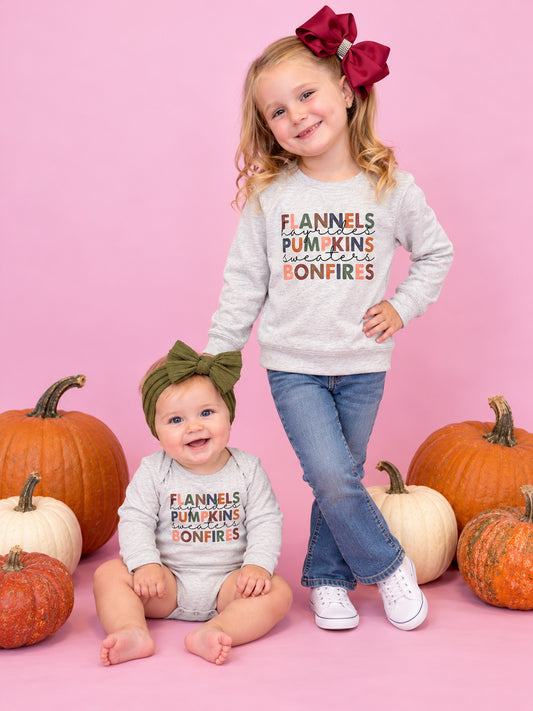 Sisters wearing Flannels, pumpkins and bonfires shirt and onesie