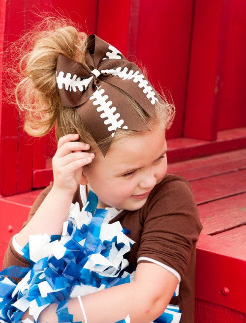 Girl wearing a football cheer bow on a ponytail