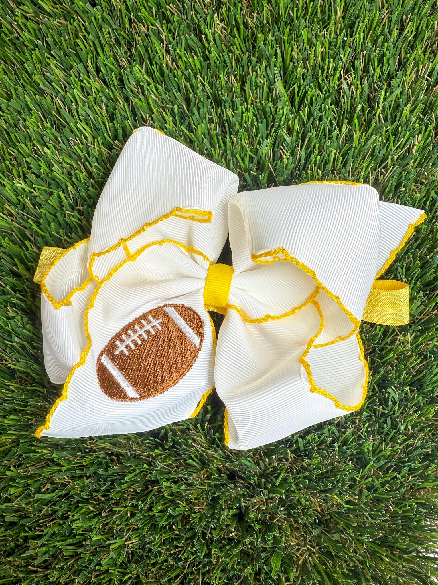 Large decorative bow with football design on grass