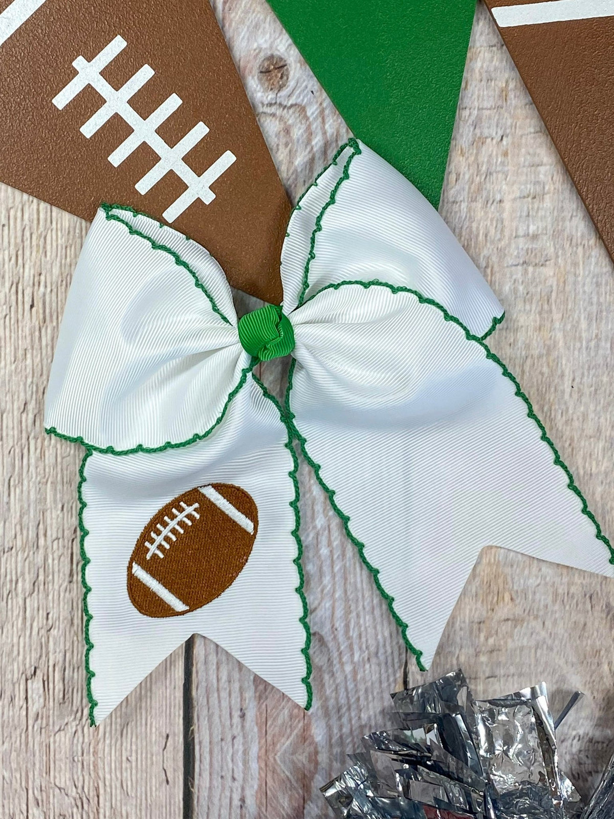 White football embroidered moonstitch cheer bow with green stitching