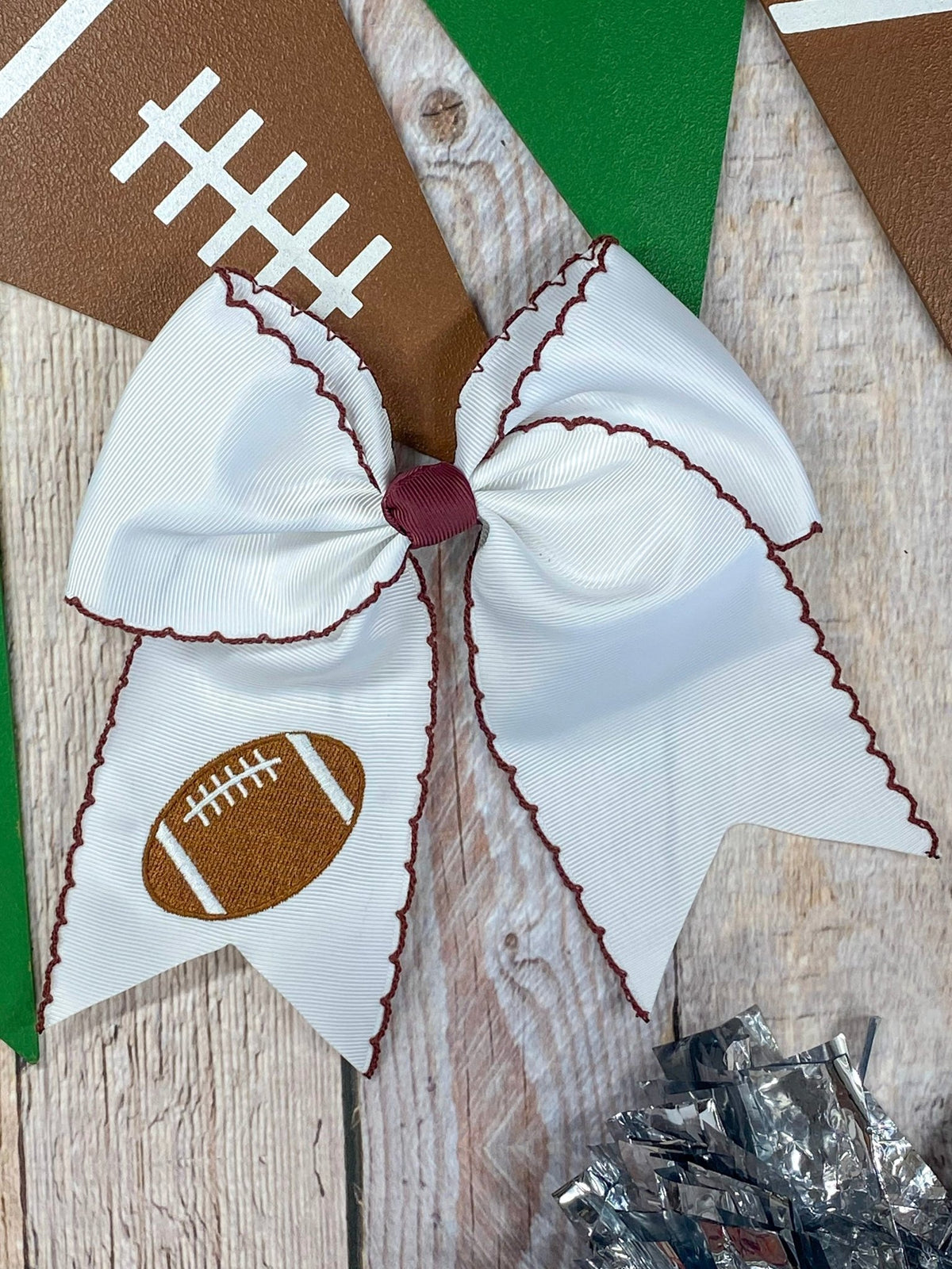 White football embroidered moonstitch cheer bow with maroon stitching