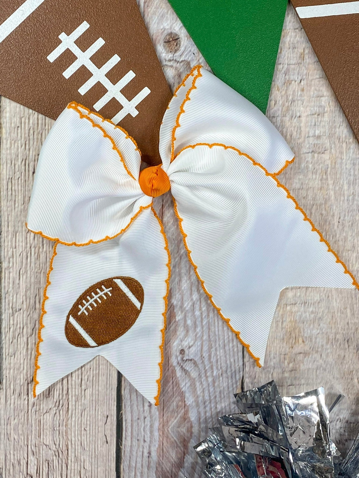 White football embroidered moonstitch cheer bow with orange stitching
