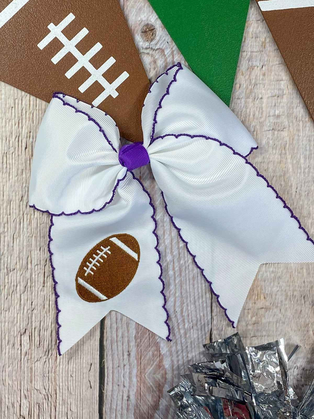 White football embroidered moonstitch cheer bow with purple stitching