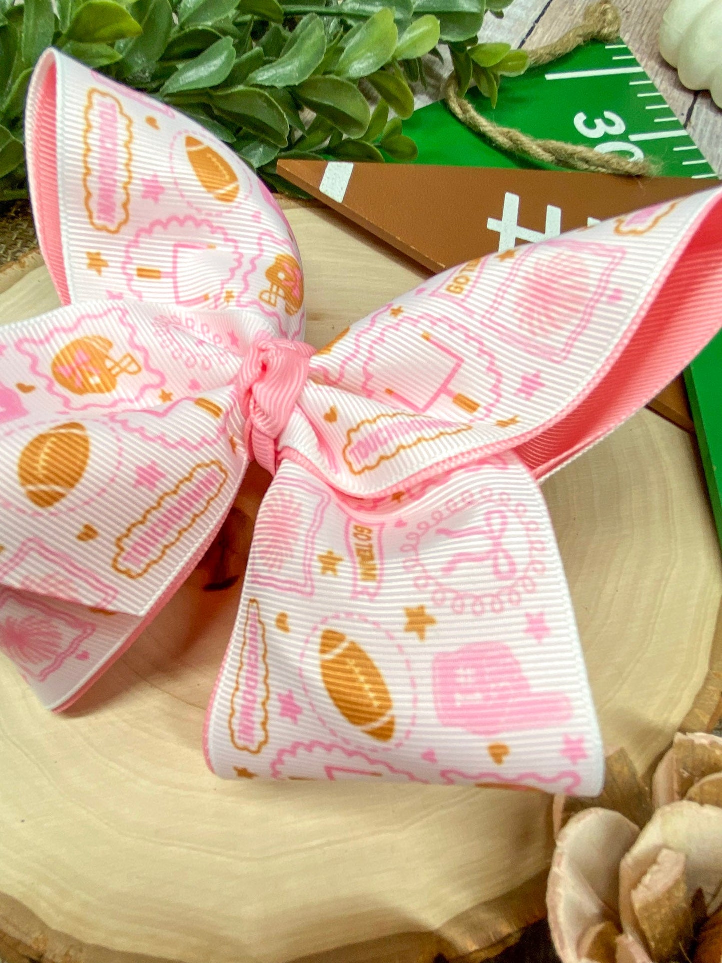 Football Print Pink Double Layer Hair Bow on a wooden background