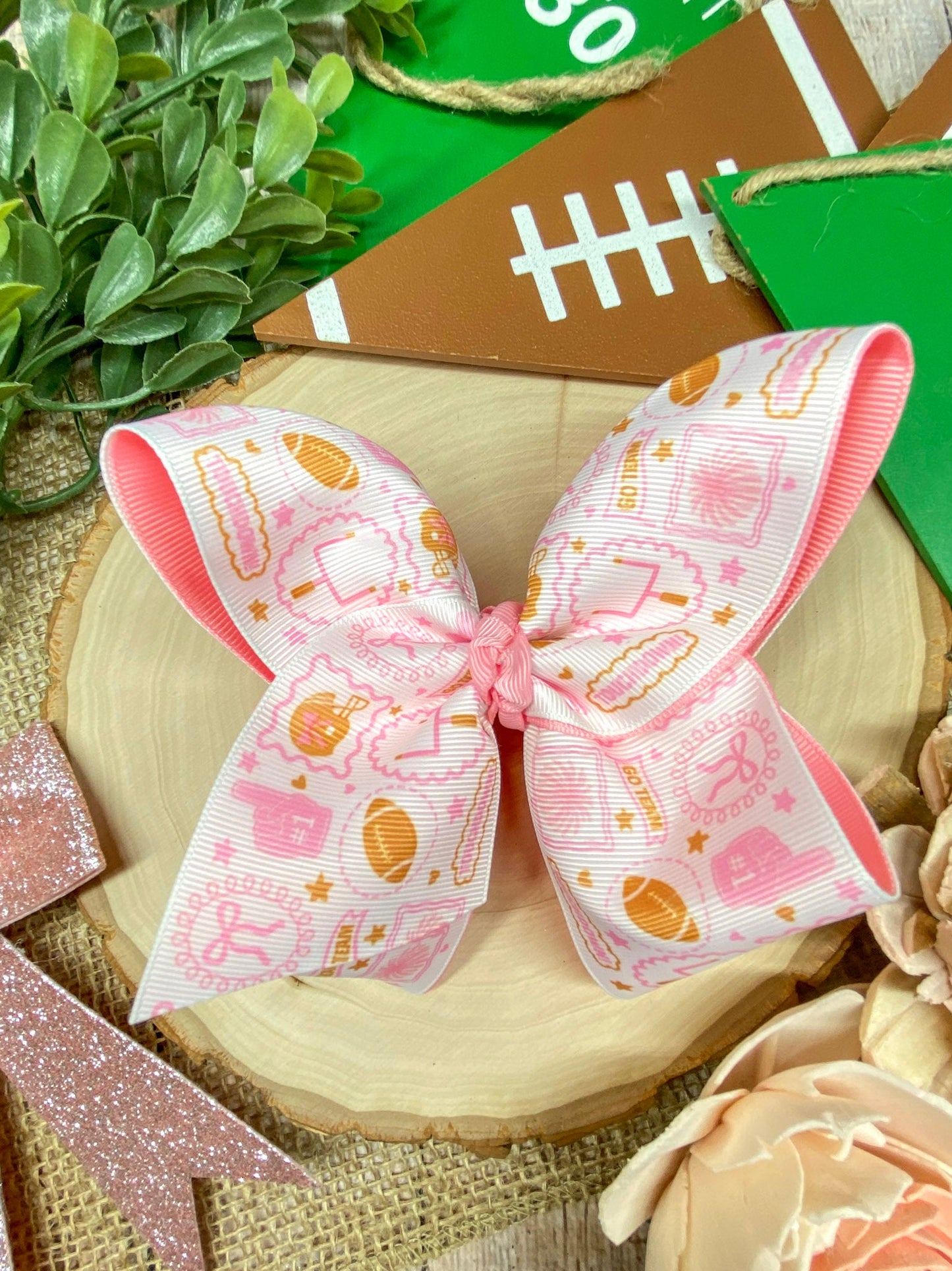 Football Print Pink Double Layer Hair Bow on a wooden background
