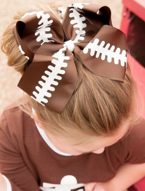 Girl wearing a football Texas size hair bow