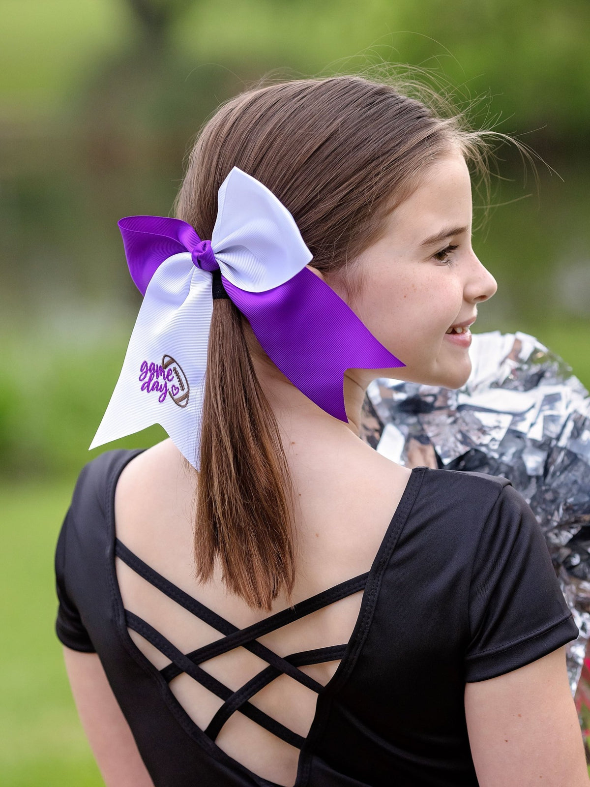 Girl wearing a game day embroidered cheer bow