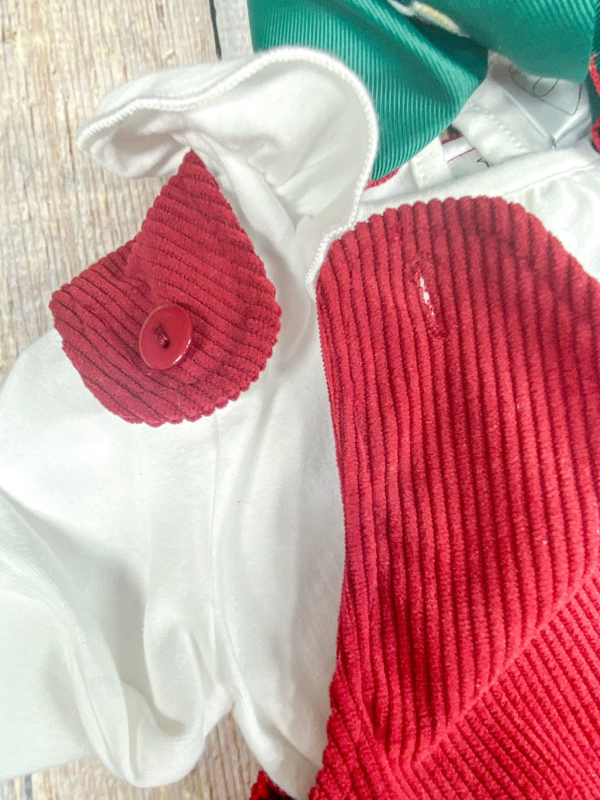 Close-up of the red corduroy jumper's unbuttoning shoulder