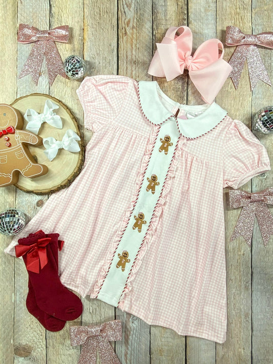 Pink gingham girls Christmas dress with embroidered gingerbread men, Peter Pan collar, and ruffle trim – perfect holiday outfit.