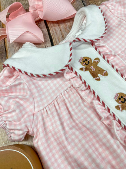 Pink checkered outfit with gingerbread design on a wooden surface